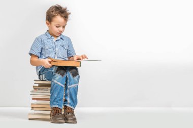 Yakışıklı bir yığın kitap beyaz bir arka plan üzerinde oturan bir kitapla
