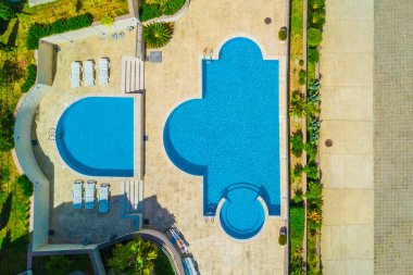 Şezlong üzerinde yalan insanlar yakınındaki havuzu, üstten görünüm