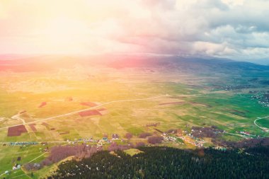 Güneş ışığı altında dağlarda bir köyün üstten görünüm