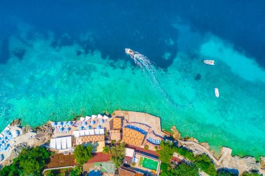 Şezlong ve denizin üstten görünüm beyaz tekne ile kayalık plaj