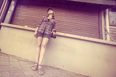 Şapkalı ve bir kamera konumu duvarın yanında olan kadın