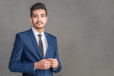 Gri bir arka plan üzerinde mavi elbiseli Genç çekici adam