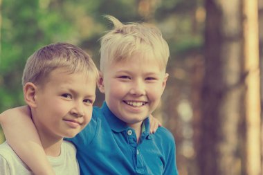 Beyaz ve mavi T-shirt iki sarışın erkek ayakta parkta sarılma