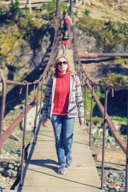 Bir grup insan üzerinde bir asma köprü dağlarda yürüyüş