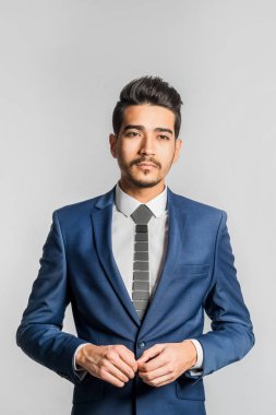 Gri bir arka plan üzerinde mavi elbiseli Genç çekici adam. İzole