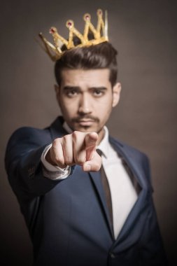 Kafasında bir taç ile mavi elbiseli Genç çekici adam. Tonda 