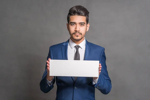 Young Attractive Man Blue Suit Holding White Sign Gray Background — Stock Photo, Image