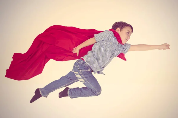 Boy Flying Red Cloak Superhero Beige Background — Stock Photo, Image
