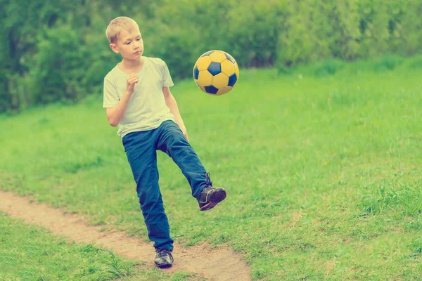 Blond Chłopiec Kopnięcia Piłki Nożnej Chodnik Parku — Zdjęcie stockowe