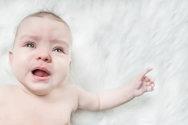 Huilende Baby Ligt Een Witte Pluizige Achtergrond — Stockfoto