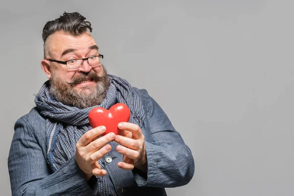 Взрослый Бородатый Мужчина Синей Куртке Шарфе Отвращением Держащий Красное Сердце — стоковое фото