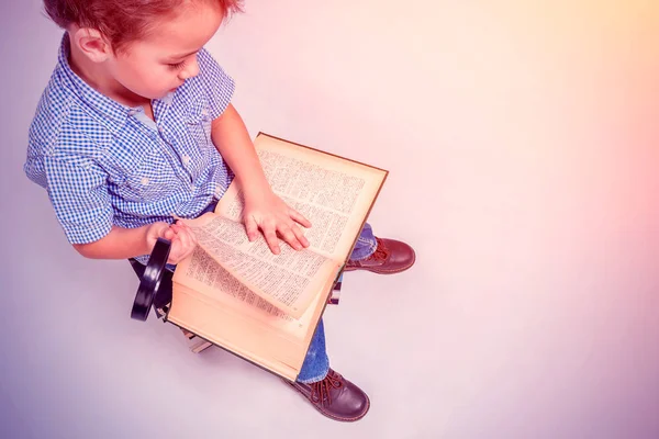 Niño Con Lupa Leyendo Libro Sentado Montón Libros Sobre Fondo — Foto de Stock