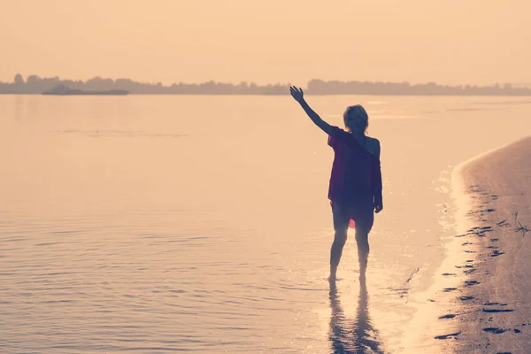 Teenager Steht Mit Erhobener Hand Wasser Bei Sonnenuntergang — Stockfoto