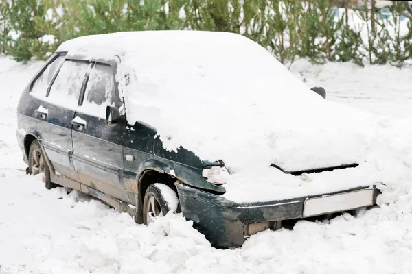 古い汚れた駐車中の車が雪で覆われて — ストック写真