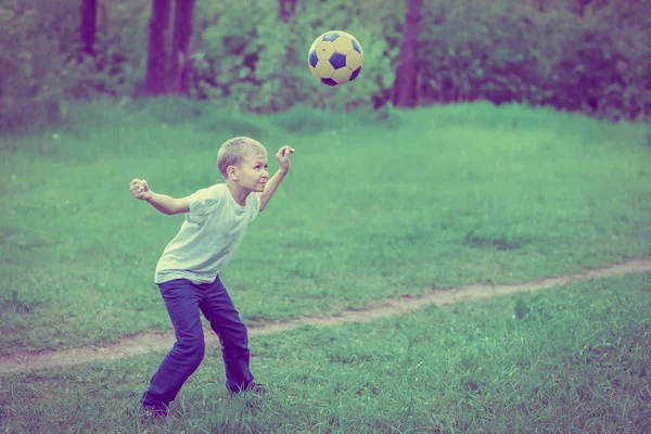 Blonde Jongen Speelt Met Een Voetbal Het Park Toned — Stockfoto