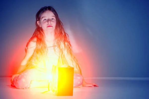 Menina Olha Saco Presente Brilhante Vermelho Quarto Escuro — Fotografia de Stock