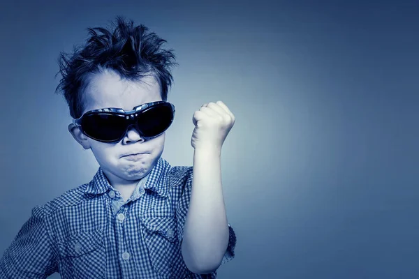 Niño Con Una Camisa Azul Gafas Sol Amenaza Con Puño — Foto de Stock