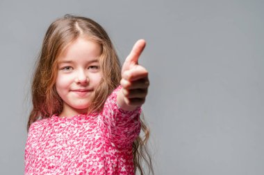 Başparmak gri bir arka plan üzerinde kırmızı bluz kız ortaya
