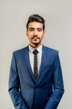 Gri bir arka plan üzerinde mavi elbiseli Genç çekici adam. İzole