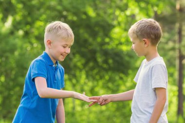 İki sarışın erkek taş kağıt makas parkta oynamak