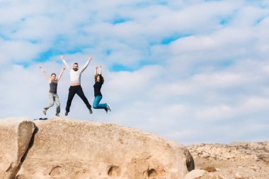 Bir grup insan bir dağın tepesinde atlama