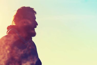 Güneşli bir gün, bir ceketli bir mohawk saç kesimi olan sakallı bir adam portresi