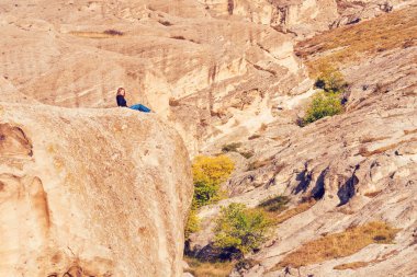 Bir dağın tepesinde oturan kadın