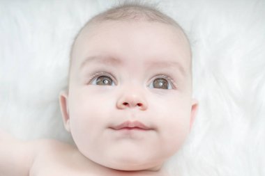 Şirin bebek üzerinde beyaz bir kürk yalan