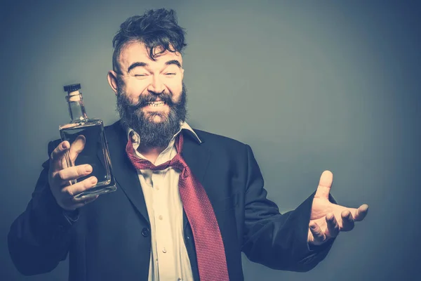 Radosny Pijane Brodaty Mężczyzna Garniturze Butelką Alkoholu Ręku Stonowanych — Zdjęcie stockowe