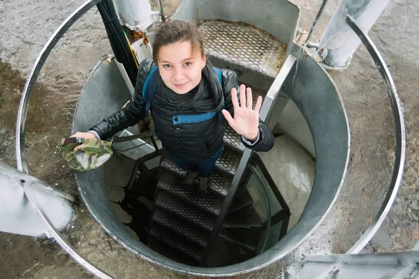 Young beautiful woman climbs the stairs in a round tower