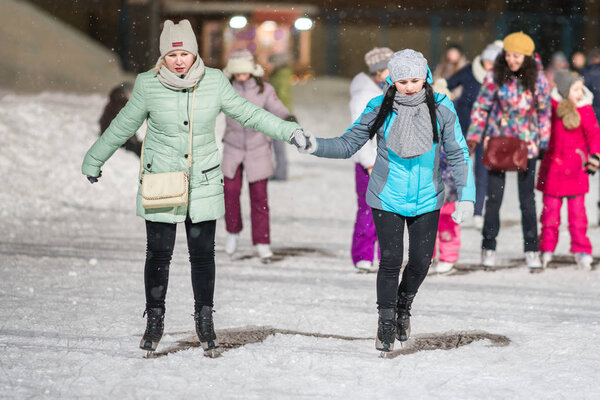 КАЗАН, РОССИЯ, 22 ЯНВАРЯ, 2017: Две женщины на катке вечером
