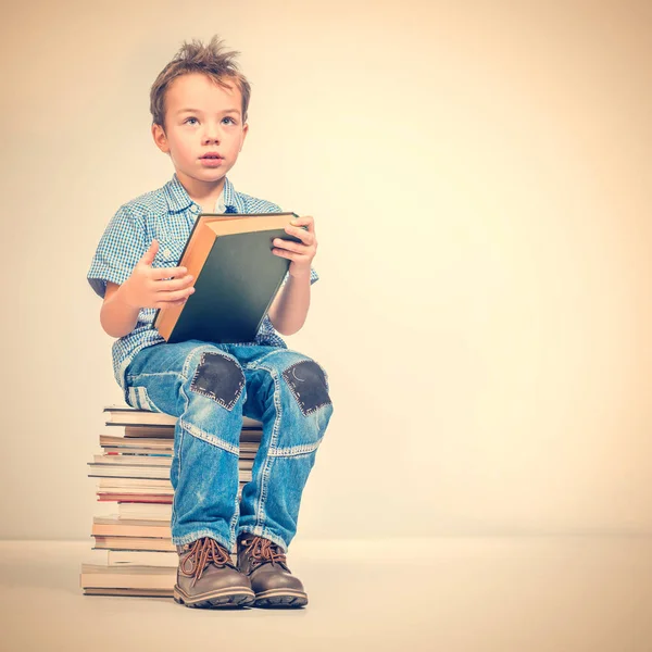 Lindo Chico Con Una Camisa Azul Sentado Montón Libros Sosteniendo — Foto de Stock