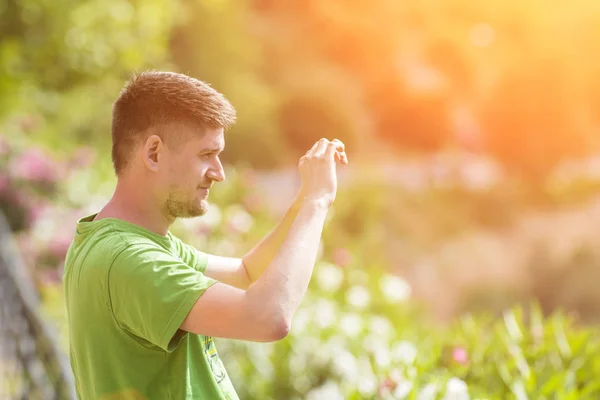 Człowiek Zielony Shirt Sprawia Zdjęcie Telefonie Parku — Zdjęcie stockowe
