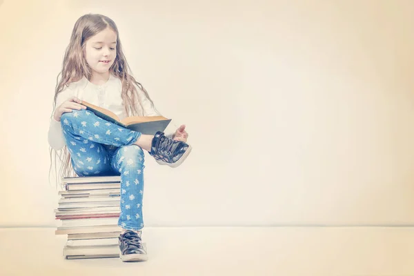 Menina Bonito Com Livro Sentado Uma Pilha Livros Fundo Bege — Fotografia de Stock