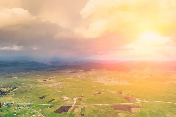 Top view of a mountain valley and asphalt road at sunset