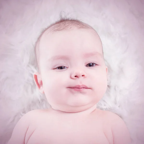 Симпатичный Малыш Лежит Белом Мехе Toned — стоковое фото