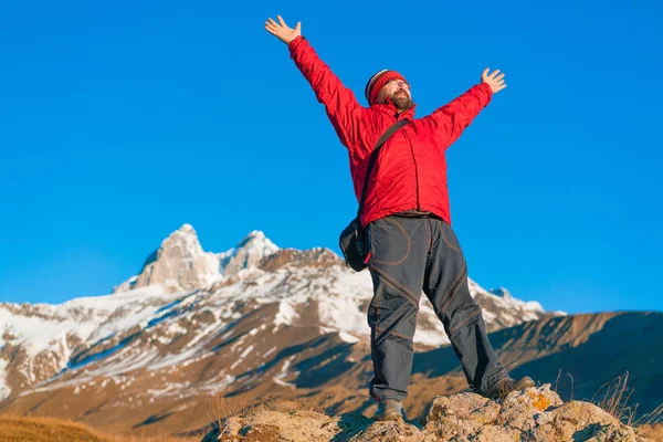 Γενειοφόρος Άνδρας Ένα Κόκκινο Σακάκι Στέκεται Χέρια Ψηλά Στα Βουνά — Φωτογραφία Αρχείου