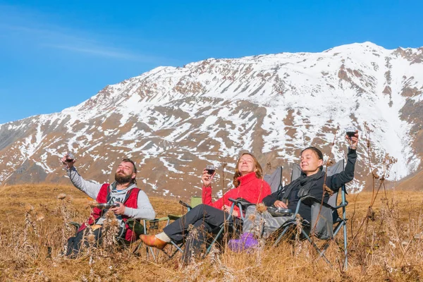 Group of people are drinking wine in the mountains