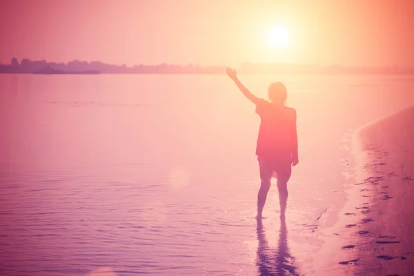 Teenager Steht Mit Erhobener Hand Wasser Bei Rosa Sonnenuntergang — Stockfoto