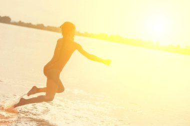 Suya atlamak. Çocuk eğleniyor ve suya su sıçrıyor. Yaz tatili kavramı