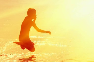 Suya atlamak. Çocuk eğleniyor ve suya su sıçrıyor. Yaz tatili kavramı