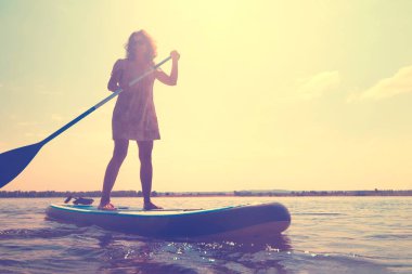 Sup nehirüzerinde kürek ile Surf kız ayağa kalk