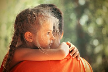 Küçük kız babasına dışarıda sarılıyor