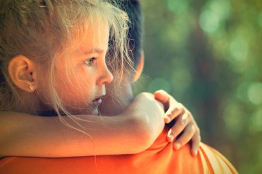 Küçük kız babasına dışarıda sarılıyor