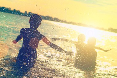 Suya atlamak. Çocuklar eğlenir ve suya sıçratıyor. Yaz tatili konsepti