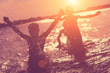 Suya atlamak. Çocuklar eğlenir ve suya sıçratıyor. Yaz tatili konsepti