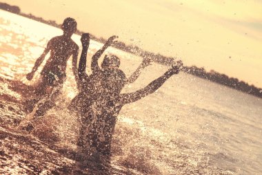 Suya atlamak. Çocuklar eğlenir ve suya sıçratıyor. Yaz tatili konsepti