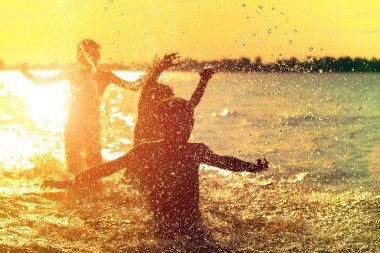 Suya atlamak. Çocuklar eğlenir ve suya sıçratıyor. Yaz tatili konsepti