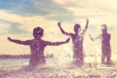 Suya atlamak. Çocuklar eğlenir ve suya sıçratıyor. Yaz tatili konsepti