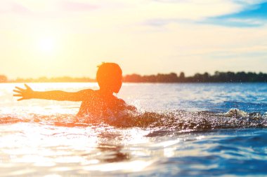 Suya atlamak. Çocuk eğleniyor ve suya su sıçrıyor. Yaz tatili kavramı